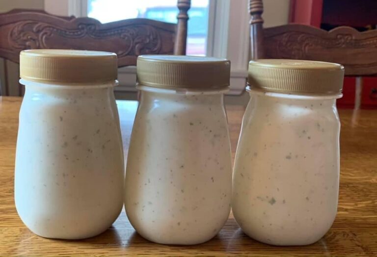A bowl of creamy homemade ranch dressing surrounded by fresh vegetables for dipping.